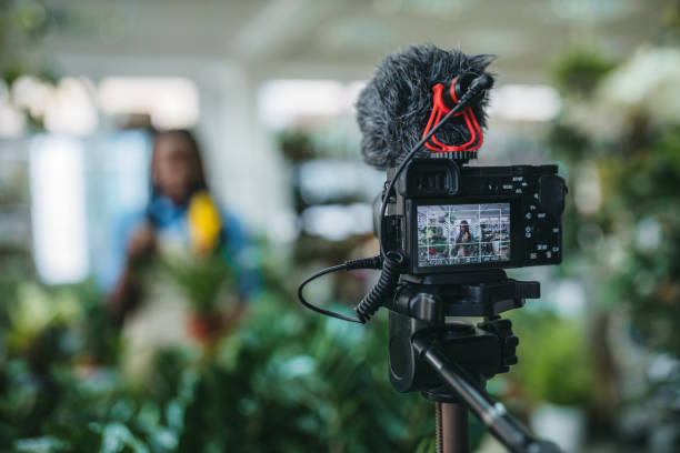 istock Young woman vlogging in greehouse 1300233381