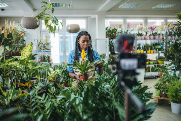istock Young woman vlogging in greehouse 1300233382