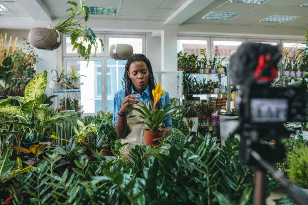 istock Young woman vlogging in greehouse 1300233387