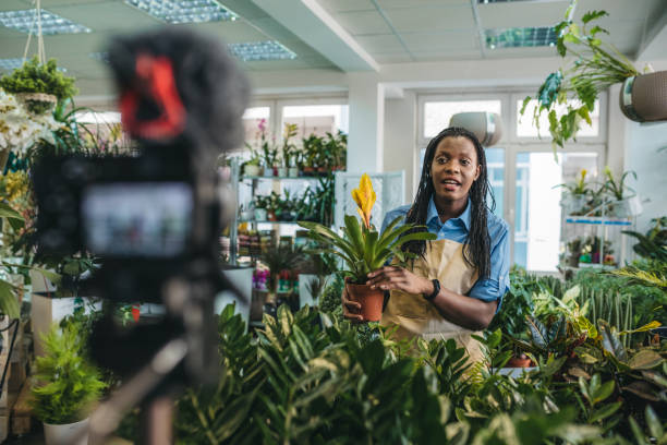 istock Young woman vlogging in greehouse 1300233408