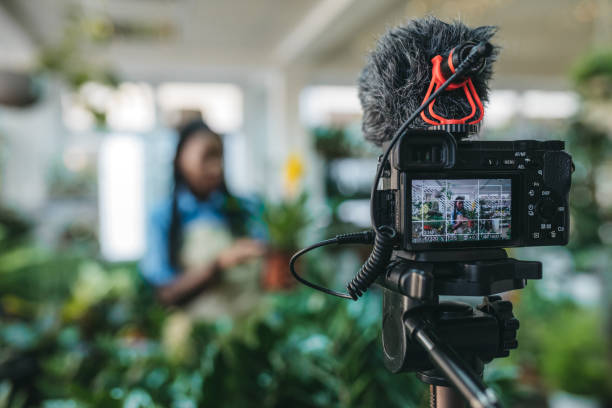 istock Young woman vlogging in greehouse 1300233410