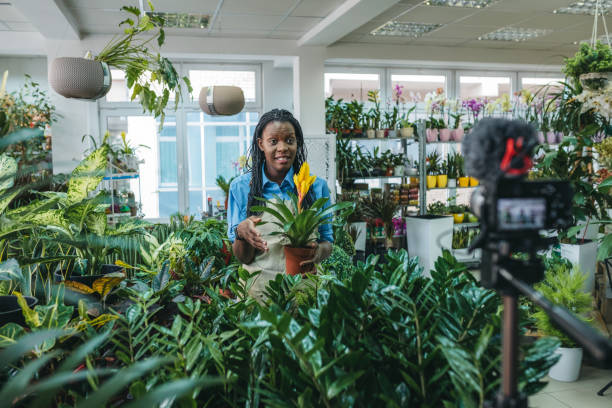 istock Young woman vlogging in greehouse 1300233994