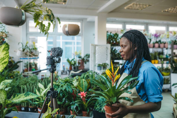 istock Young woman vlogging in greehouse 1300233995
