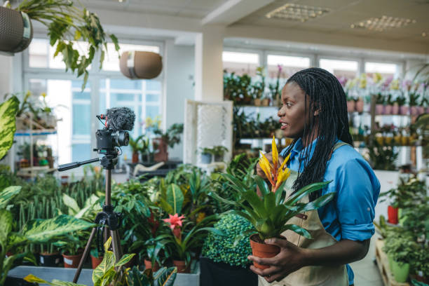 istock Young woman vlogging in greehouse 1300233997