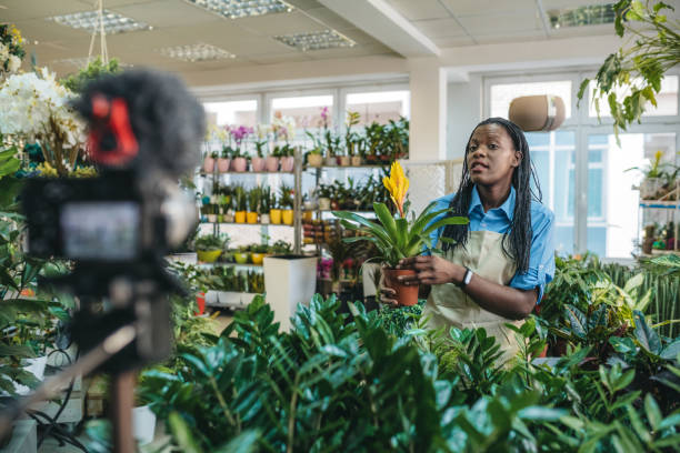 istock Young woman vlogging in greehouse 1300234028