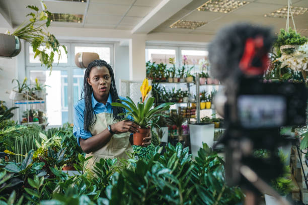 istock Young woman vlogging in greehouse 1300234031