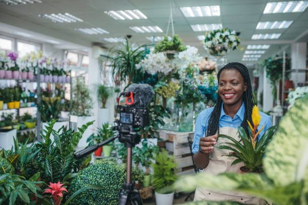 istock Young woman vlogging in greehouse 1300234041