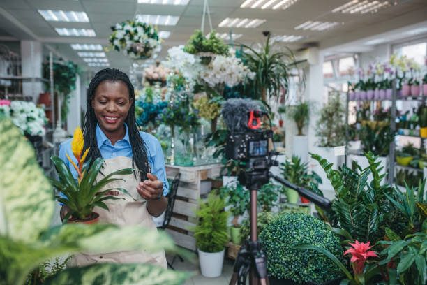 istock Young woman vlogging in greehouse 1300234043