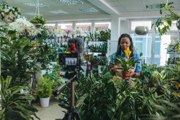istock Young woman vlogging in greehouse 1300234044