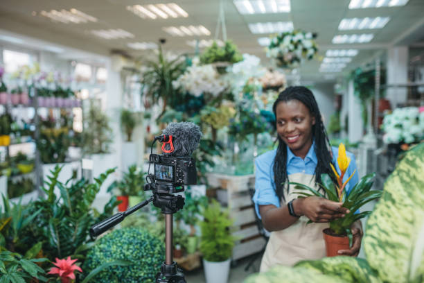 istock Young woman vlogging in greehouse 1300234057