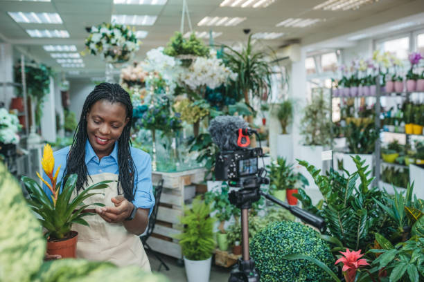 istock Young woman vlogging in greehouse 1300234068