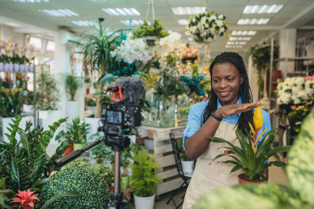 istock Young woman vlogging in greehouse 1300234070