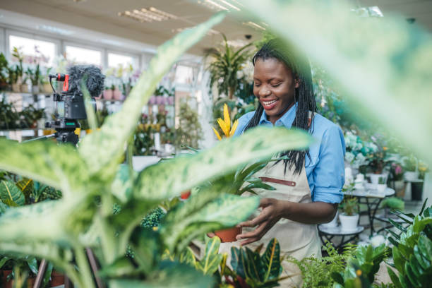 istock Young woman vlogging in greehouse 1300234076