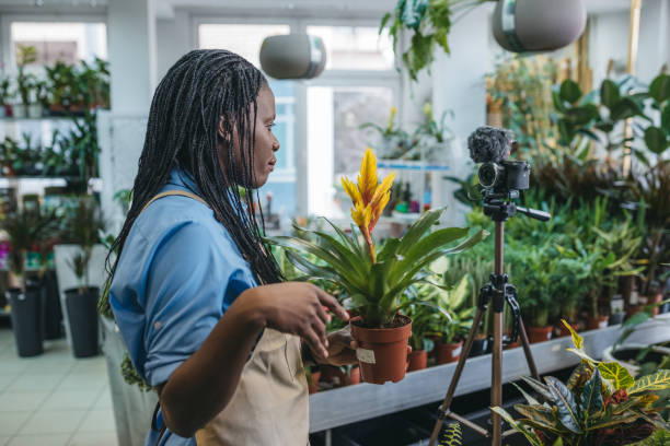 istock Young woman vlogging in greehouse 1300234099