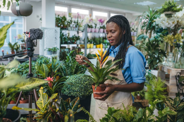 istock Young woman vlogging in greehouse 1300234117