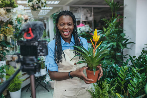 Young woman vlogging in greehouse