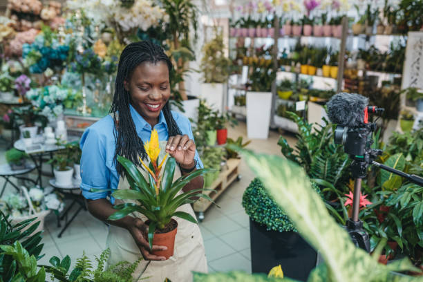 istock Young woman vlogging in greehouse 1300234181