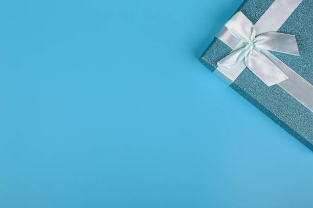 istock Christmas background. Blue glitter gift box with bow on a blue background. Empty space for text, top view, flat lay 1300234256