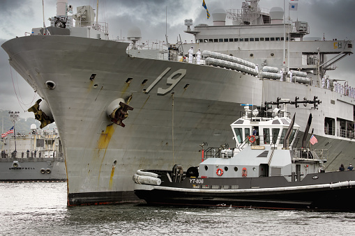 Navy frigate enters a harbour after offshore training exercises.