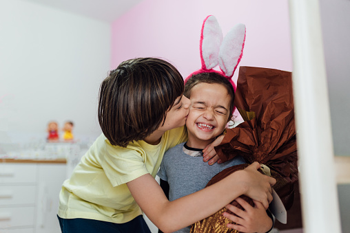 Brother hugs his sister with Easter egg