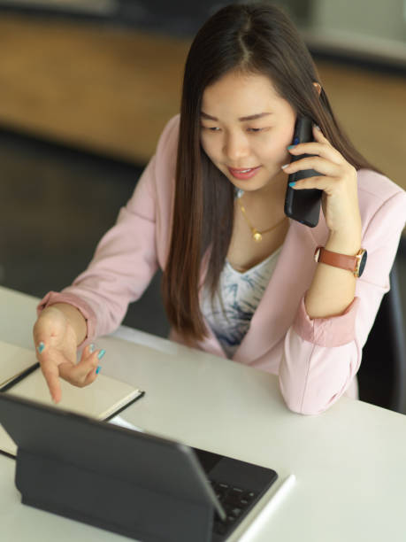 istock Businesswoman talking on the phone while working with digital tablet on the table 1300237807