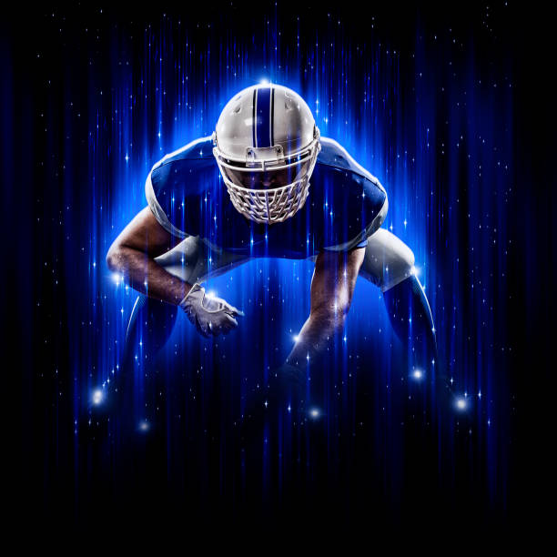 held fußballer trägt eine blaue uniform - football helmet american football yellow american football uniform stock-fotos und bilder