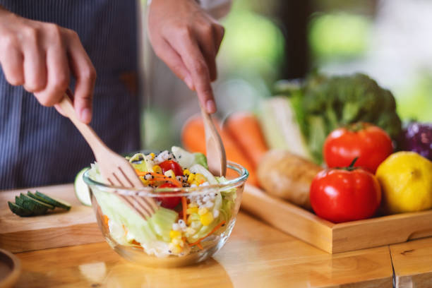 istock a female chef cooking fresh mixed vegetables salad in kitchen 1300244181