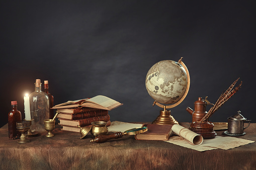 Desktop of a scientist, writer, or student of past centuries. Vintage items, books and manuscripts on a dark background. Space for your text