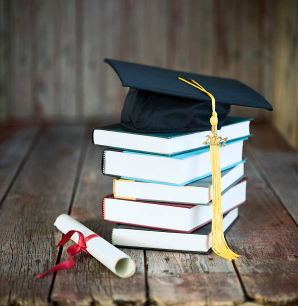 istock Graduation Cap and Diploma Concept on a Wood Background 1300251655