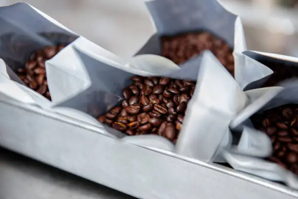 Dark roasted coffee beans in a plastic bag