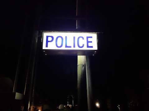Illuminated Police station sign. Street picture at night