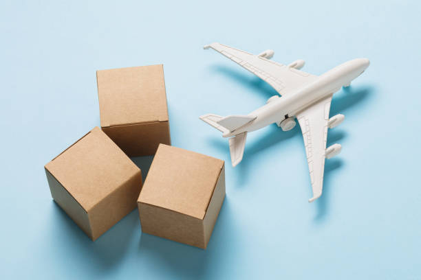 istock Toy plane and cardboard boxes on a blue background. Cargo delivery concept 1300254577