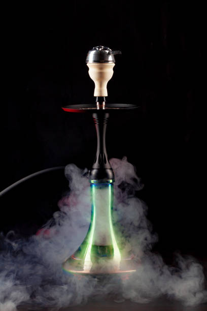 istock Smoking hookah on black background with color fog 1300255431