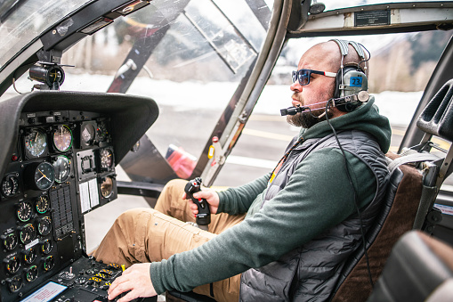 Pilot inside a helicopter cockpit. Preflight check.