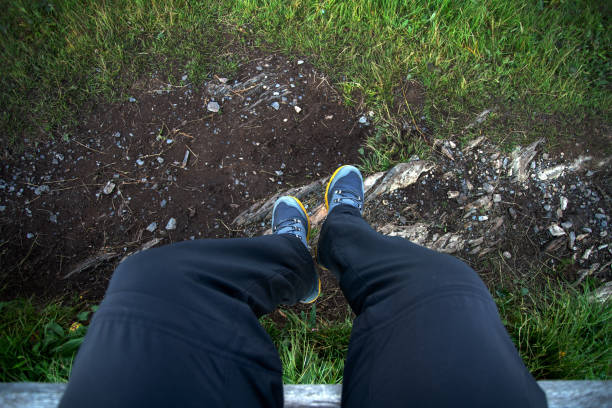 Man dangling feet over water