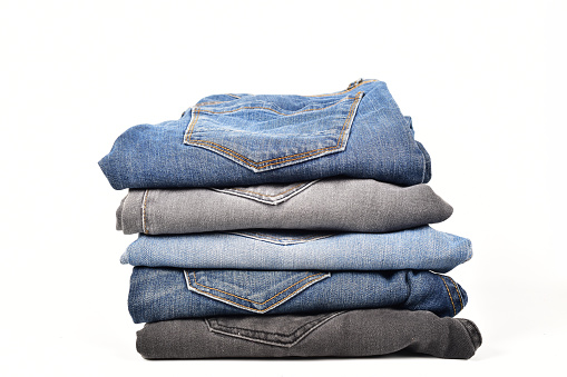 Stack of folded jeans isolated on white background with clipping path