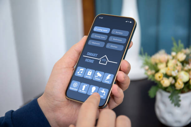 mani maschili tiene il telefono con l'applicazione smart home sullo schermo - domotica foto e immagini stock