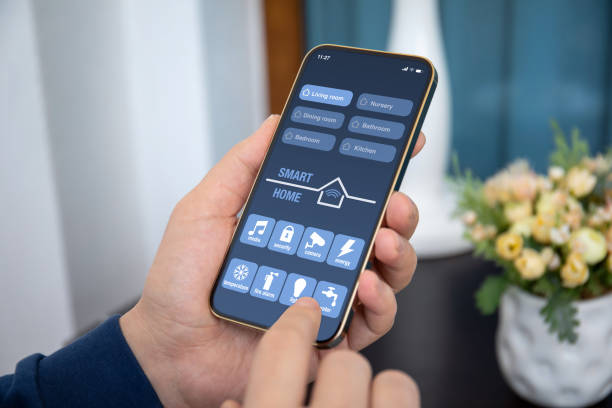 男性の手は、画面上のスマートホームアプリケーションで電話を保持します - ホームオートメーション ストックフォトと画像