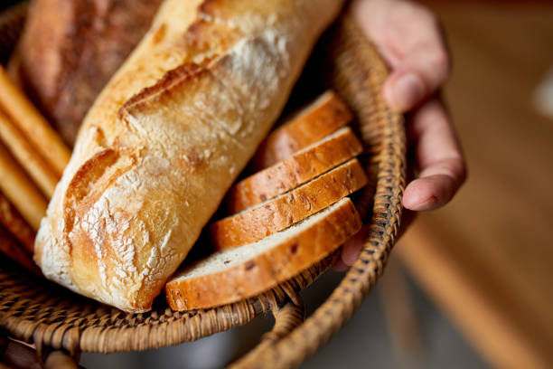 istock Close yp of man hand, holding basket with various bread freshly baked. 1300263473