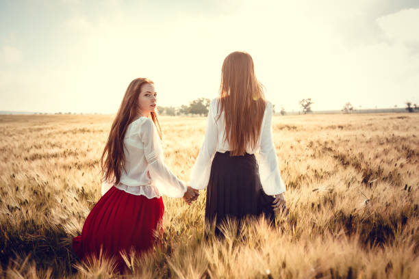 istock Two young women are looking forward tothe sunset. Best friends 1300266111
