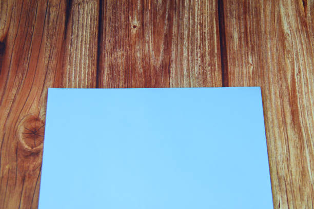istock Blue blank sheet of paper on wooden background with copyspace 1300267298