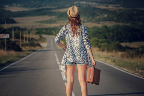 istock women is hailing a car on a road 1300270612