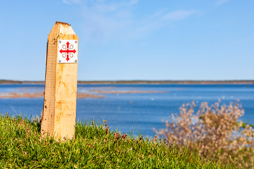 Signpost at a Pilgrim way with a lake view