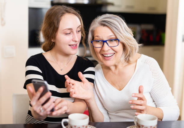 istock Mother with daughter using smartphone 1300272211