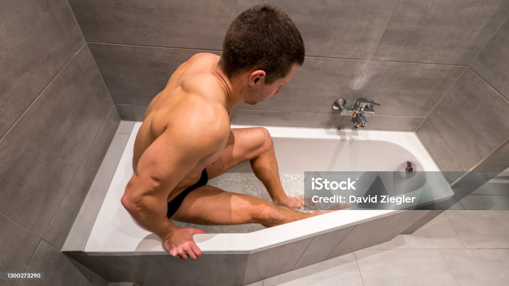 Uomo Seduto In Una Vasca Da Bagno Piena Di Cubetti Di Ghiaccio