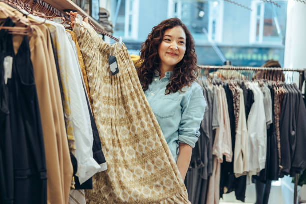 istock Clothing store owner assisting customer 1300273323