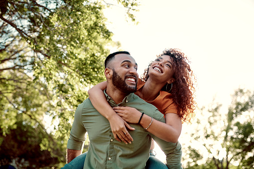 Young carefree couple having fun while dancing in nature. Copy space.