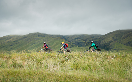 Three people cycling the Otago Central Rail Trail towards Middlemarch, South Island, New Zealand