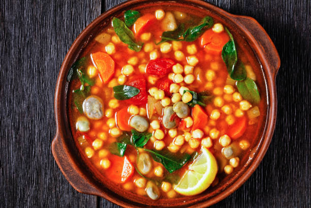istock chickpea and green broad bean Moroccan soup in an earthenware bowl on a rustic wooden table, close-up 1300275242