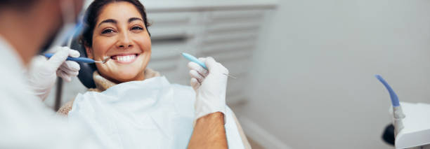 Woman getting dental treatment Dentist examining teeth of a female patient in dental clinic using dental tools. Happy woman getting dental treatment. dentists office stock pictures, royalty-free photos & images